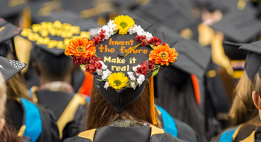 Student with decorated mortar board during commencement